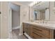 Bathroom features double sinks with a wood vanity and view to the closet at 36014 Poinsettia Ave, Fruitland Park, FL 34731