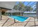 A stunning view of the screened-in pool and lake from the house with brick pavers is perfect for relaxing at 36014 Poinsettia Ave, Fruitland Park, FL 34731