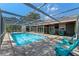 Relaxing screened-in pool area featuring a sparkling in-ground pool, comfortable seating and nice patio pavers at 36014 Poinsettia Ave, Fruitland Park, FL 34731