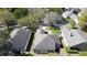 Overhead view of three homes in a residential neighborhood with mature trees and well-kept lawns at 3725 Westerham Dr, Clermont, FL 34711