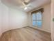 Bright bedroom showcasing wood flooring, a ceiling fan, and a window with blinds and curtains at 3725 Westerham Dr, Clermont, FL 34711