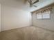 Cozy bedroom with neutral carpet, a ceiling fan, a window with blinds, and a classic white door at 3725 Westerham Dr, Clermont, FL 34711