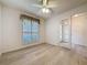 Neutral bedroom showcases wood-look flooring, a ceiling fan, a large window with blinds, and French doors at 3725 Westerham Dr, Clermont, FL 34711