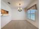 Bright dining room featuring neutral carpet, chandelier, and pass-through to the kitchen at 3725 Westerham Dr, Clermont, FL 34711