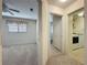 Neutral hallway leading to a bedroom and a utility room with a full-size washer and dryer at 3725 Westerham Dr, Clermont, FL 34711