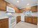 Kitchen with white appliances and wood cabinets at 3725 Westerham Dr, Clermont, FL 34711