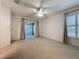 A carpeted main bedroom with a ceiling fan, plantation shutters, and access to the sunroom at 3725 Westerham Dr, Clermont, FL 34711