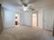 Carpeted main bedroom featuring a ceiling fan, ensuite bathroom, and a walk-in closet at 3725 Westerham Dr, Clermont, FL 34711