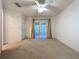 Carpeted main bedroom featuring a ceiling fan, with sliding glass door access to the sunroom at 3725 Westerham Dr, Clermont, FL 34711