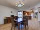 Bright dining room features beautiful chandelier and light wood floors adjacent to the kitchen at 3733 Plantation Blvd, Leesburg, FL 34748