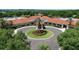 Aerial view of the clubhouse with beautiful landscaping and a circular driveway at 3773 Eversholt St, Clermont, FL 34711