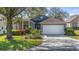 Charming home featuring a well-manicured lawn, vibrant landscaping, and a two-car garage at 3773 Eversholt St, Clermont, FL 34711