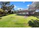 Expansive backyard featuring lush green lawn and mature trees, with a view of the two-story home and covered porch at 37734 N County Road 44A, Eustis, FL 32736