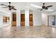 Bright living room features tile flooring, ceiling fans, built-in bookcases, and a skylight for natural light at 37734 N County Road 44A, Eustis, FL 32736