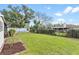 Spacious backyard with green grass, a defined border, and distant view of the home at 402 Firewood Ave, Eustis, FL 32726