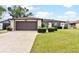 Well-maintained home exterior featuring a two-car garage and landscaped front yard at 402 Firewood Ave, Eustis, FL 32726