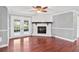 Bright living room with hardwood floors, a fireplace, and French doors leading to the backyard at 402 Firewood Ave, Eustis, FL 32726