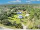 Lovely aerial view of the property with a house, pond, outbuildings, a circular driveway, and lush vegetation at 42141 Chinaberry St, Eustis, FL 32736