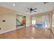 Bright living room with hardwood floors, a ceiling fan, and large windows with white curtains at 42141 Chinaberry St, Eustis, FL 32736