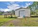 Exterior view of an outbuilding with a metal roll-up door and a covered lean-to at 42141 Chinaberry St, Eustis, FL 32736