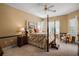 Comfortable bedroom featuring a four-poster bed, ceiling fan, and natural light at 5029 Greenbriar Trl, Mount Dora, FL 32757