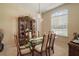 Elegant dining room with glass table, chandelier, and beautiful built-in display cabinet at 5029 Greenbriar Trl, Mount Dora, FL 32757