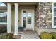 Close-up of front door with decorative glass, stone accents, and brick walkway at 5029 Greenbriar Trl, Mount Dora, FL 32757