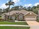 Charming home featuring stone accents, a well-manicured lawn, and a two-car garage at 5029 Greenbriar Trl, Mount Dora, FL 32757