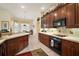 Bright kitchen with dark wood cabinets, tile countertops, and eat-in breakfast area at 5029 Greenbriar Trl, Mount Dora, FL 32757