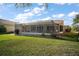 The screened-in patio has outdoor seating and overlooks the lawn with garden space at 509 Grand Vista Trl, Leesburg, FL 34748