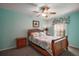 Bedroom with floral bedding, a wood frame bed, and a picturesque decorative window at 509 Grand Vista Trl, Leesburg, FL 34748