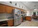 Kitchen with stainless steel appliances, wood cabinets, and breakfast area with sliding door at 509 Grand Vista Trl, Leesburg, FL 34748