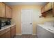 Laundry room with a white washer and dryer, and light wood cabinets above at 509 Grand Vista Trl, Leesburg, FL 34748