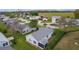 Aerial view of light blue home with screened-in patio, manicured lawn, and backyard hedge at 509 Ventura Ct, The Villages, FL 32159