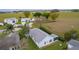 Aerial view of light blue home with a large gray roof, screened-in patio, and backyard hedge at 509 Ventura Ct, The Villages, FL 32159