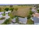 Aerial view of light blue home with a large gray roof, screened-in patio, and grassy fields nearby at 509 Ventura Ct, The Villages, FL 32159