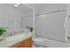 Bathroom with a shower/tub combination featuring sliding glass doors, wooden vanity, and white sink at 509 Ventura Ct, The Villages, FL 32159