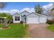 Charming light blue single-story home featuring a two-car garage and well-maintained landscaping at 509 Ventura Ct, The Villages, FL 32159