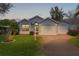 Charming light blue home exterior with a manicured front lawn, two garage doors, and manicured shrubs at 509 Ventura Ct, The Villages, FL 32159