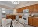 Kitchen with wood cabinets, white appliances, and a round glass table at 509 Ventura Ct, The Villages, FL 32159