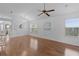 Bright and airy living room featuring wood floors, a ceiling fan, and large windows with natural light at 509 Ventura Ct, The Villages, FL 32159