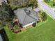 Aerial view of the property showcasing lush landscaping, a well-maintained roof, and surrounding greenery at 5144 Grove Mnr, Lady Lake, FL 32159