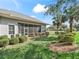 Exterior view of the home showcasing a screened patio and lush backyard landscaping at 5144 Grove Mnr, Lady Lake, FL 32159