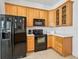 Functional kitchen with wood cabinets, black appliances, and ample counter space at 5144 Grove Mnr, Lady Lake, FL 32159