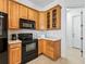 Cozy kitchen featuring wooden cabinets, black appliances, and efficient layout at 5144 Grove Mnr, Lady Lake, FL 32159