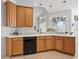 Bright kitchen featuring oak cabinetry, white countertops, black appliances, and tile flooring at 5144 Grove Mnr, Lady Lake, FL 32159