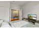 Well-lit bedroom with a TV, closet, table, and a view of the wooden floors in hallway at 5262 Royce Dr, Mount Dora, FL 32757