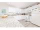 Bright kitchen featuring white cabinetry, granite countertops, and modern appliances, with an adjacent window at 527 Richburg St, The Villages, FL 32162