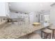 Bright kitchen with white appliances, granite countertops, and breakfast bar seating at 527 Richburg St, The Villages, FL 32162