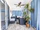 Sunroom with tile floors, blue curtains, neutral furniture, and a potted palm tree adding a tropical touch at 527 Richburg St, The Villages, FL 32162